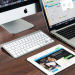 Estrategia SEO fácil para un buen posicionamiento web A sleek office desk setup featuring Apple devices: iMac, MacBook, and iPad.