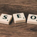 Cómo ganar en el juego SEO Scrabble tiles spelling 'SEO' on a wooden surface. Ideal for digital marketing themes.