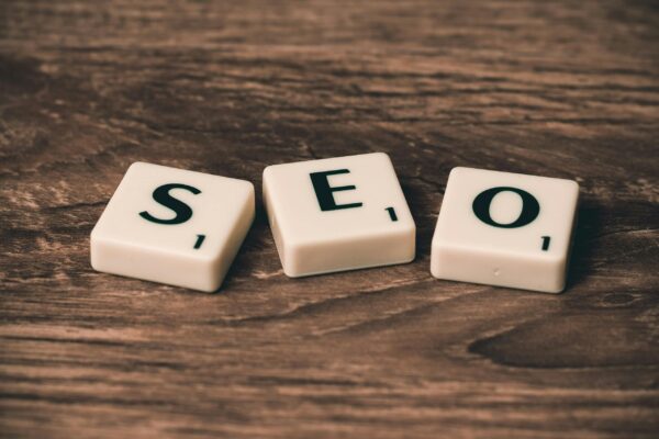 Cómo ganar en el juego SEO Scrabble tiles spelling 'SEO' on a wooden surface. Ideal for digital marketing themes.