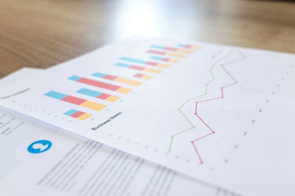Cuatro tácticas avanzadas de SEO para aumentar su tráfico A close-up view of a business document with charts and graphs on a wooden desk.